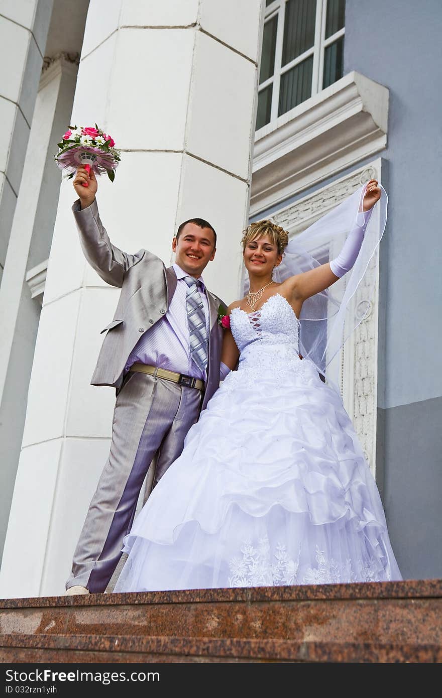 Bride and the groom on a background of a gray building