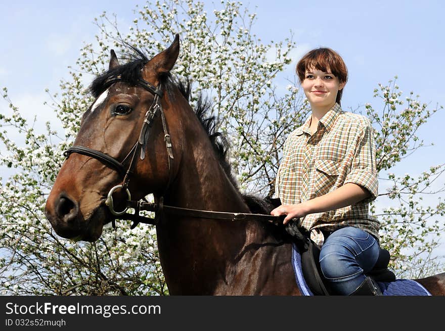 Young cowgirl and young horse in the  garden. Young cowgirl and young horse in the  garden