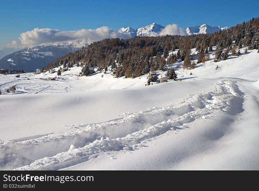 Road to Mortirolo Pass during winter. 1900 meters on the sea-level. Tarmac is under deep snow. Brixia province, Lombardy region, Italy. Road to Mortirolo Pass during winter. 1900 meters on the sea-level. Tarmac is under deep snow. Brixia province, Lombardy region, Italy