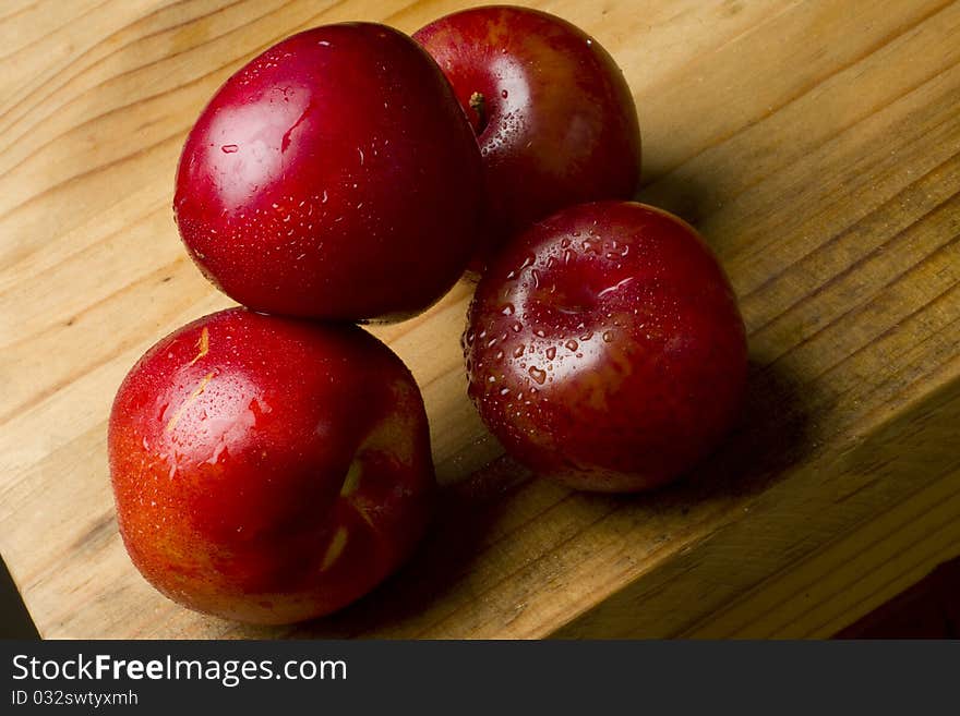 Organic red cherry plums and nectarines on a wooden table