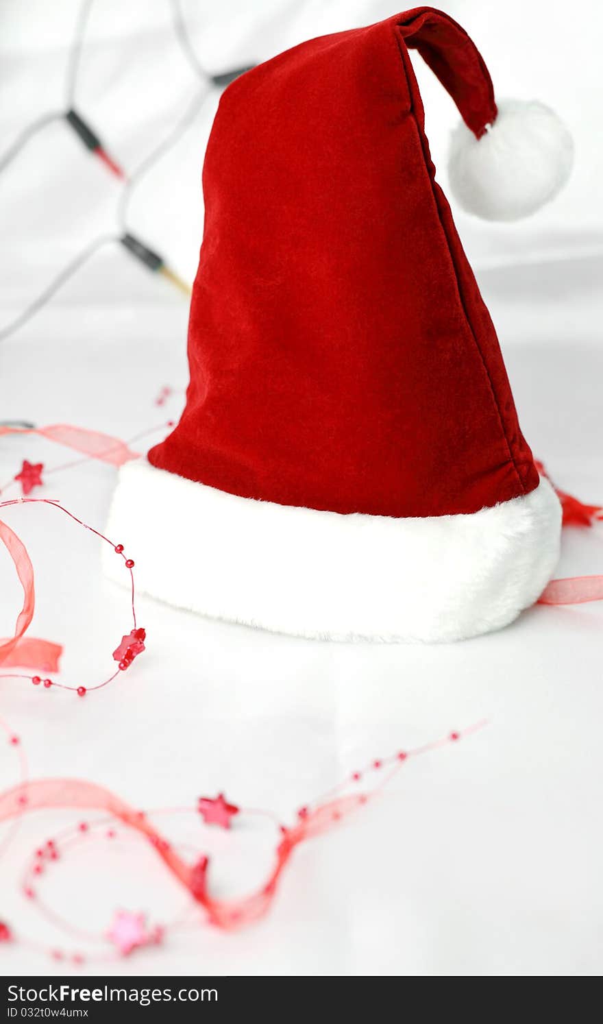 Red Santa hat on white background with ribbon