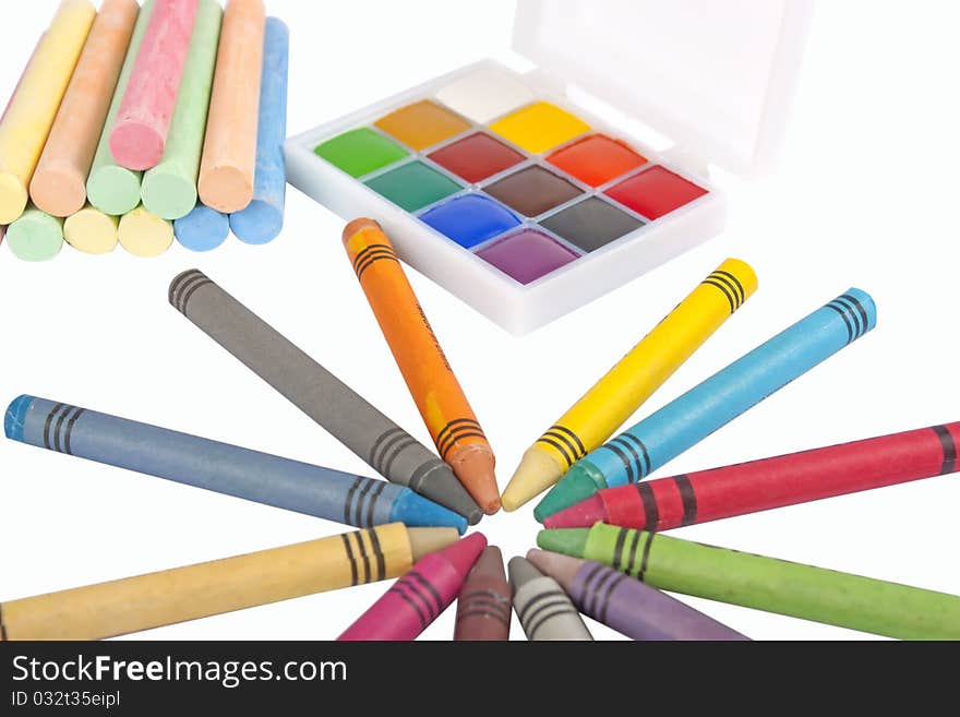 Colored wax pencils, chalk and a watercolor isolated on a on white background with clipping path