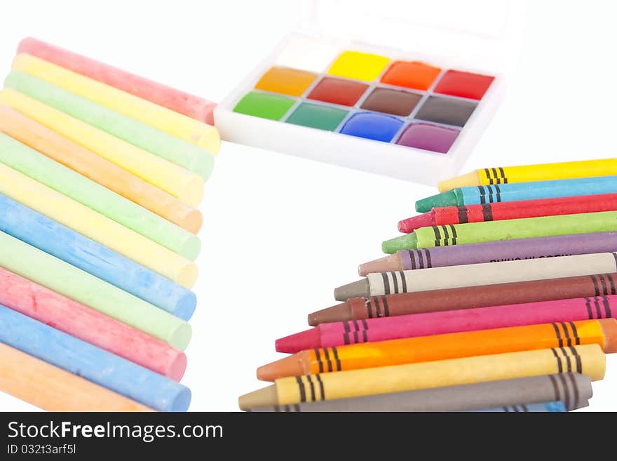 Colored wax pencils, chalk and a watercolor isolated on a on white background with clipping path