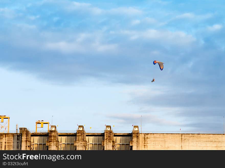 A paramotor flying high above in the blue sky