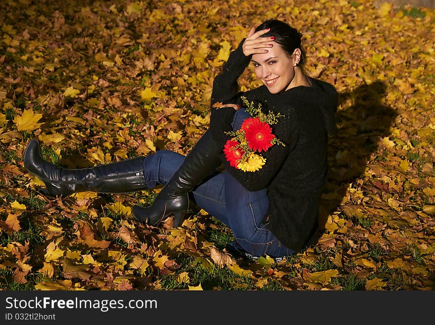 Autumn, girl with flowers on maple leaves. Autumn, girl with flowers on maple leaves