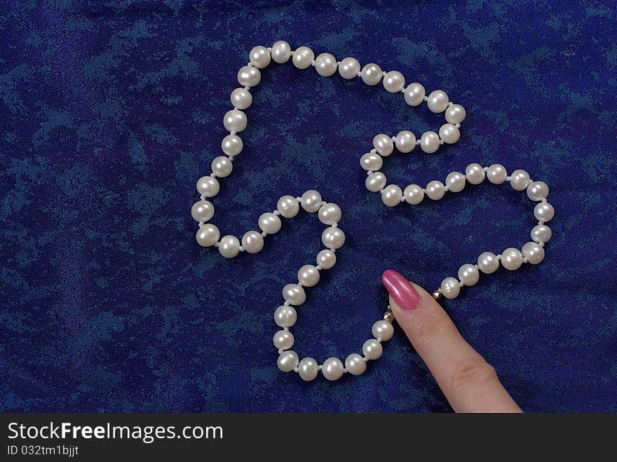 Pearl beads on the blue background. Pearl beads on the blue background