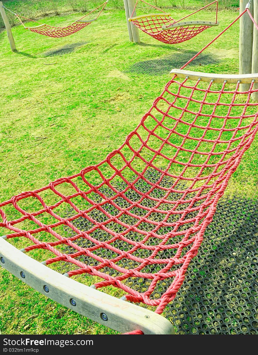 Pink hammocks hang over a lawn