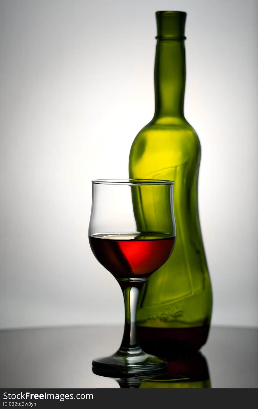 Wineglass and bottle on the desk.