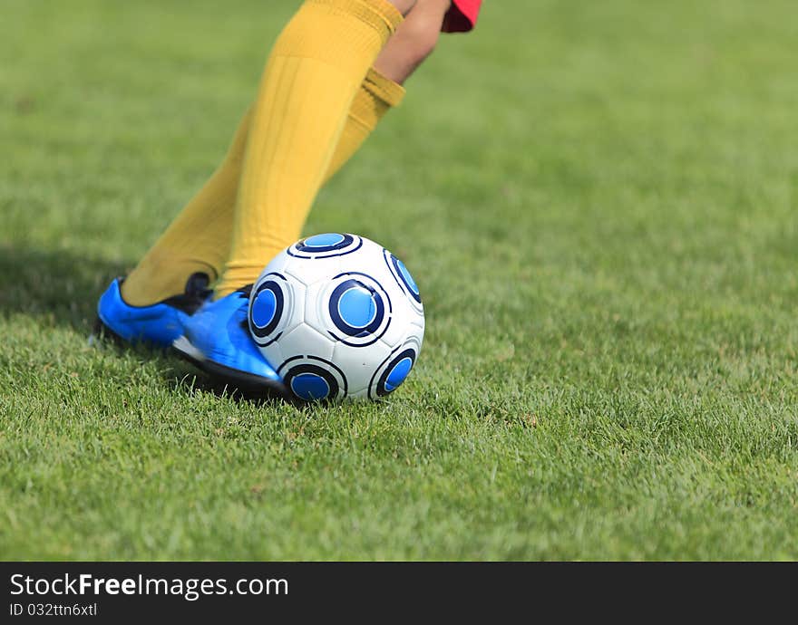 Detail image of a soccer player's leg when is kicking the ball