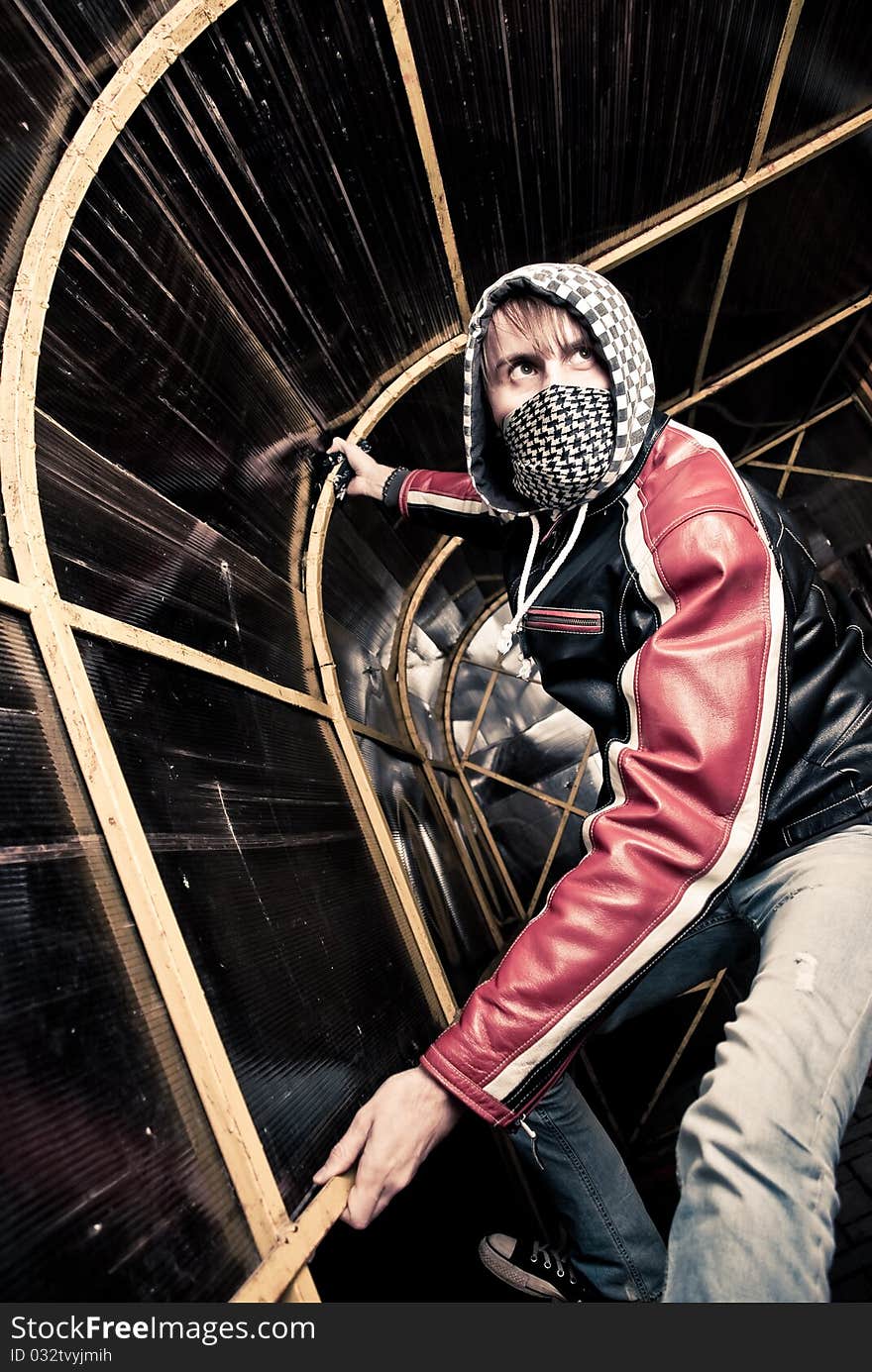 Young man in mask crawling at metal tunnel construction