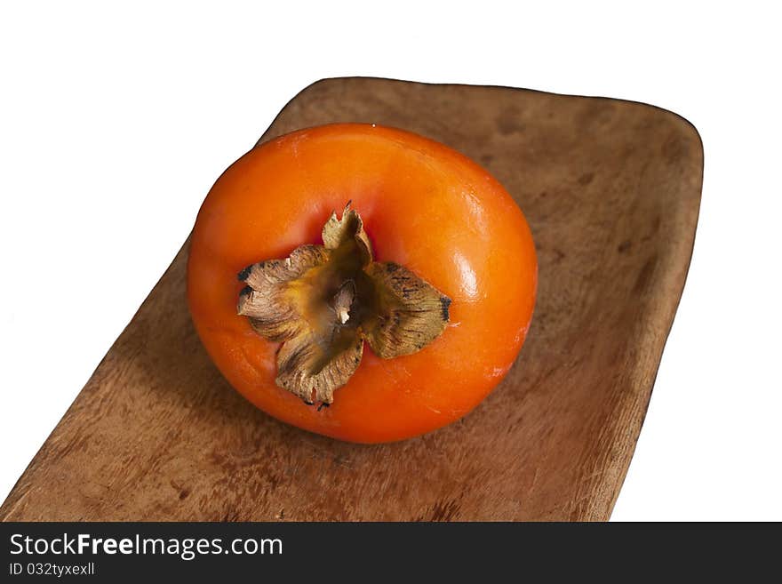 Fresh ripe persimmonon wooden plate isolated on white background