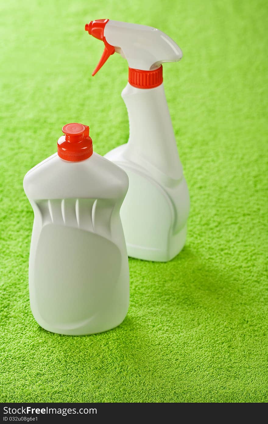 Two white bottles on green towel