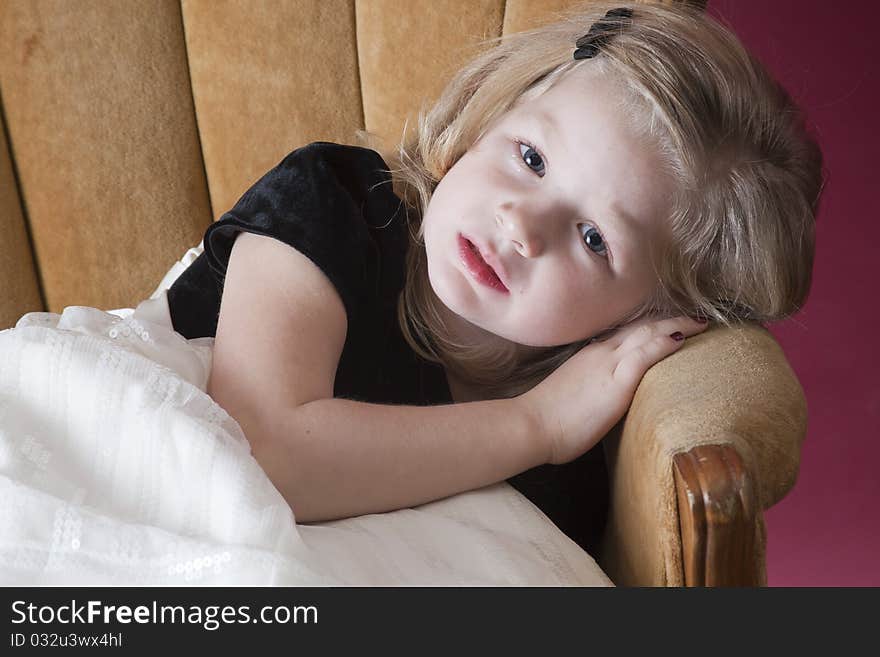 Very sad little girl sitting on chair. Very sad little girl sitting on chair