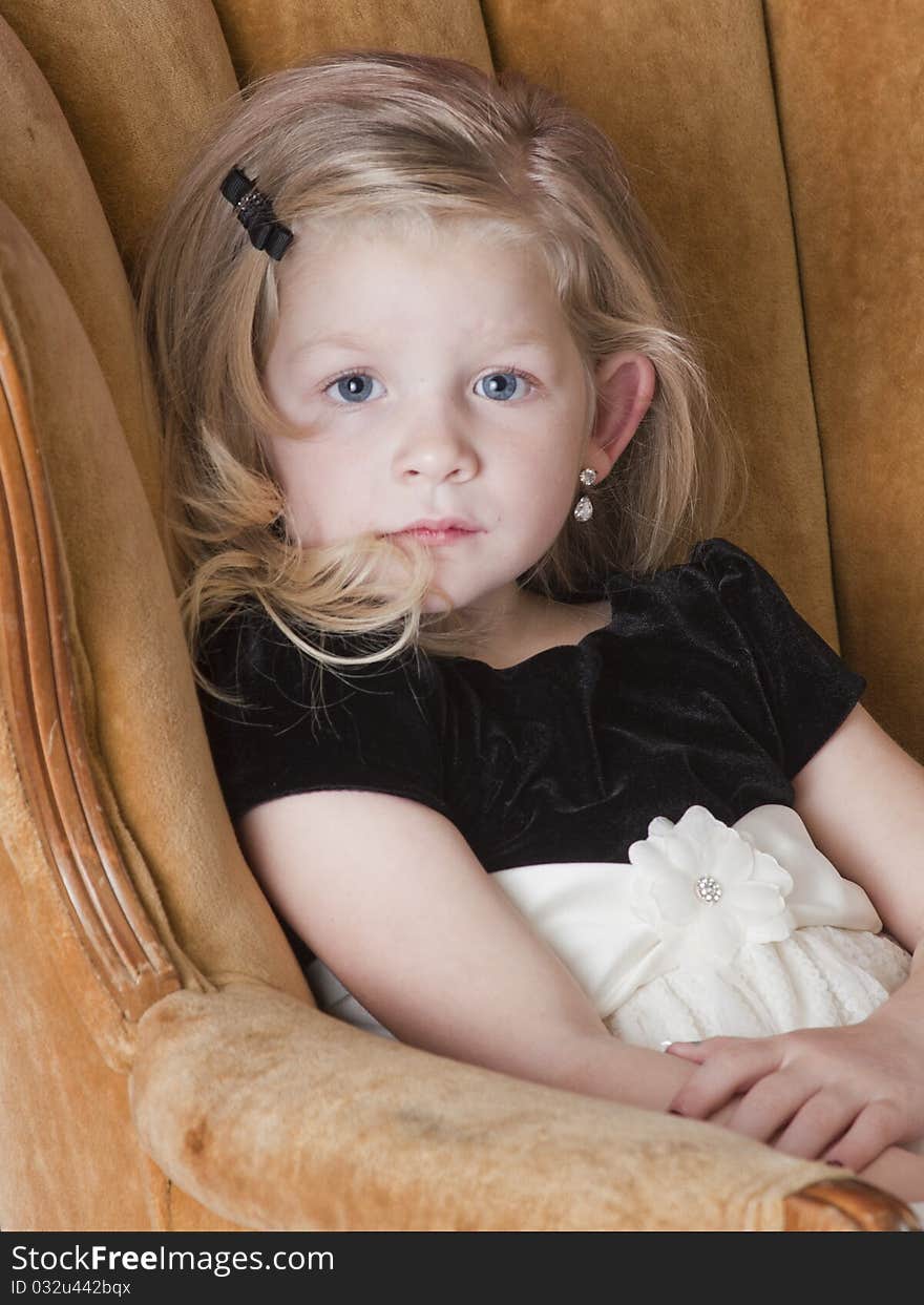 Very sad little girl standing behind couch. Very sad little girl standing behind couch