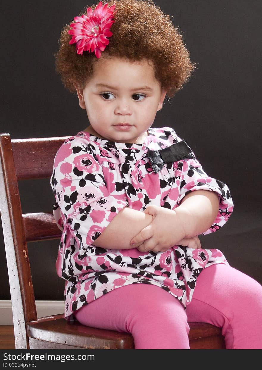 Angry toddler sitting on her chair. Angry toddler sitting on her chair