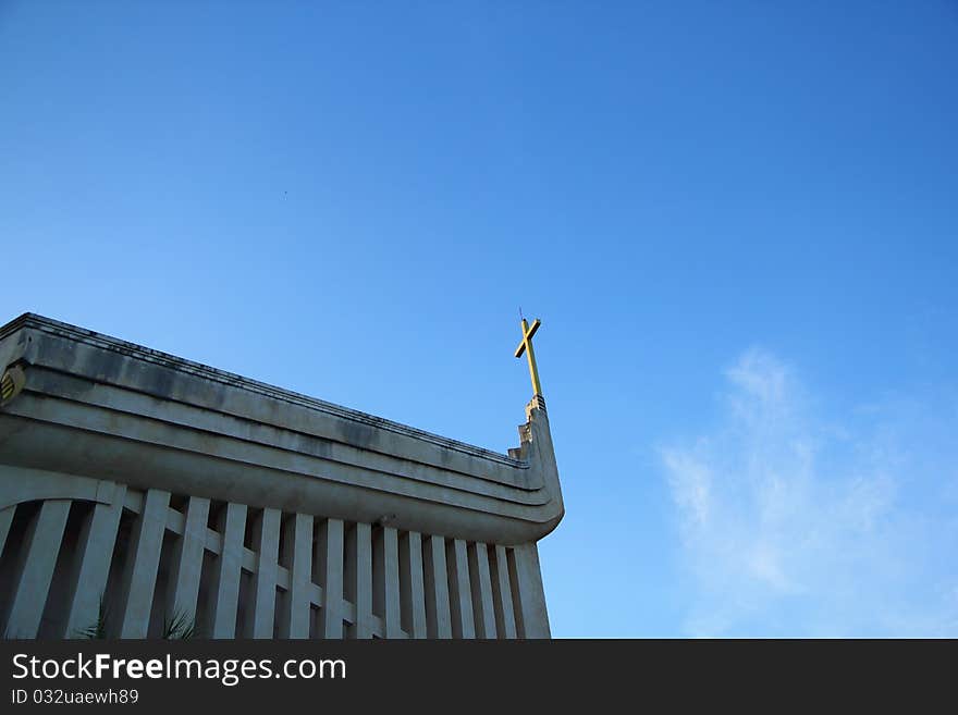 Church and cross in blue sky