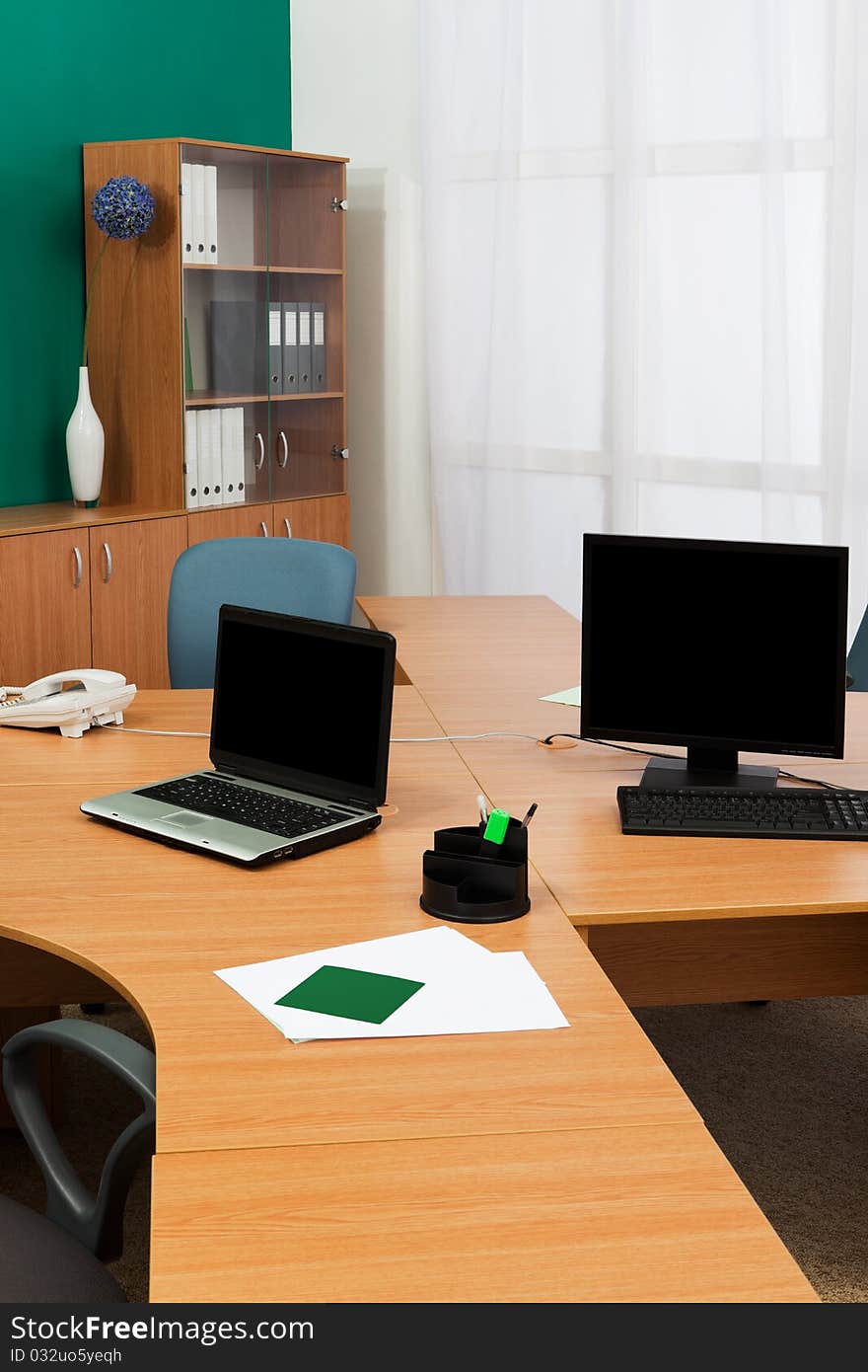 Computer and laptop on a desk at modern office