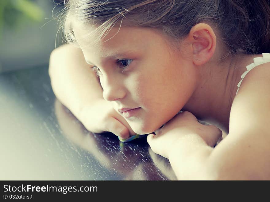 Young girl seating on the table