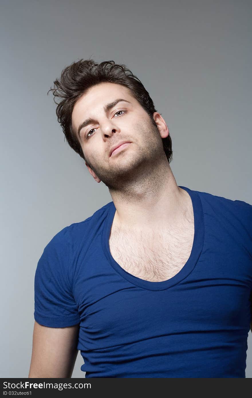 Portrait of a man in blue top looking at camera - isolated on gray. Portrait of a man in blue top looking at camera - isolated on gray