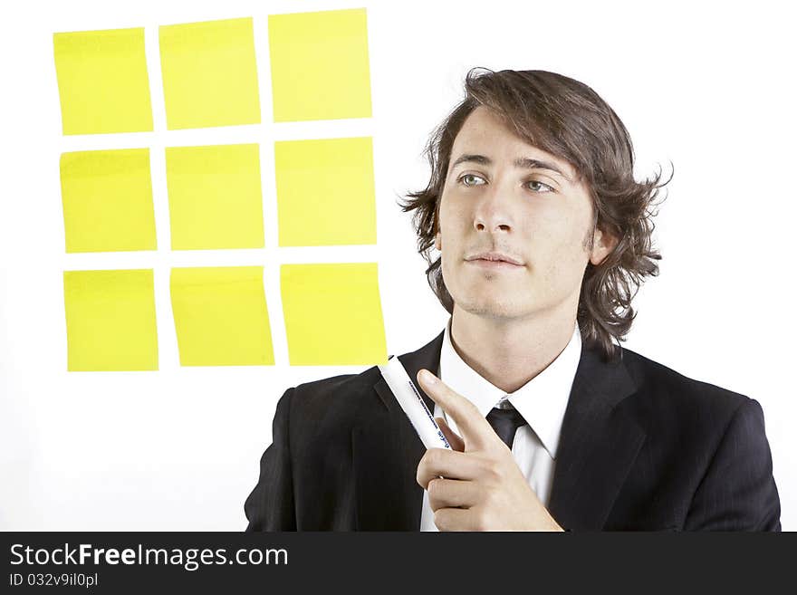 Young businessman looking at postit reminder notes on white background