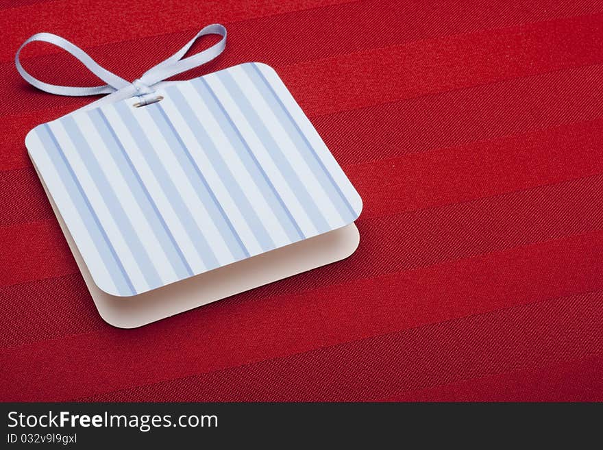 Greeting card with a blue ribbon on a red background.