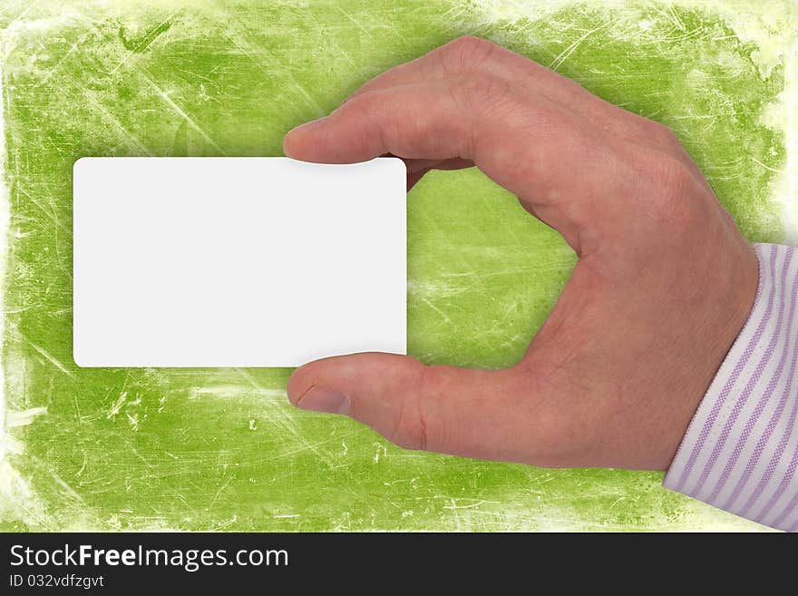 Hand with blank card on green background