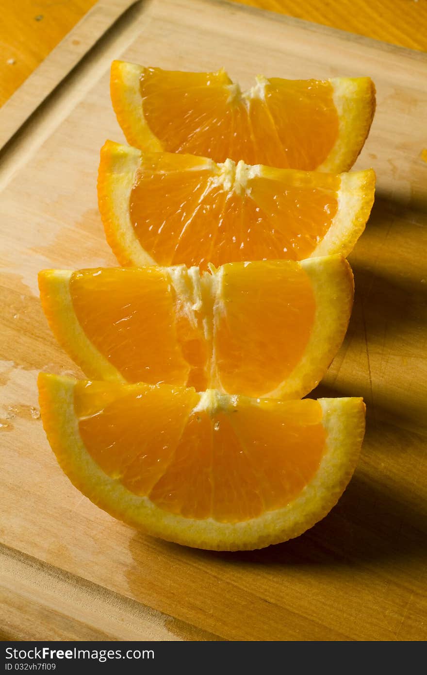 Fresh organic sweet ripe orange wedges on a wooden cutting board. Fresh organic sweet ripe orange wedges on a wooden cutting board