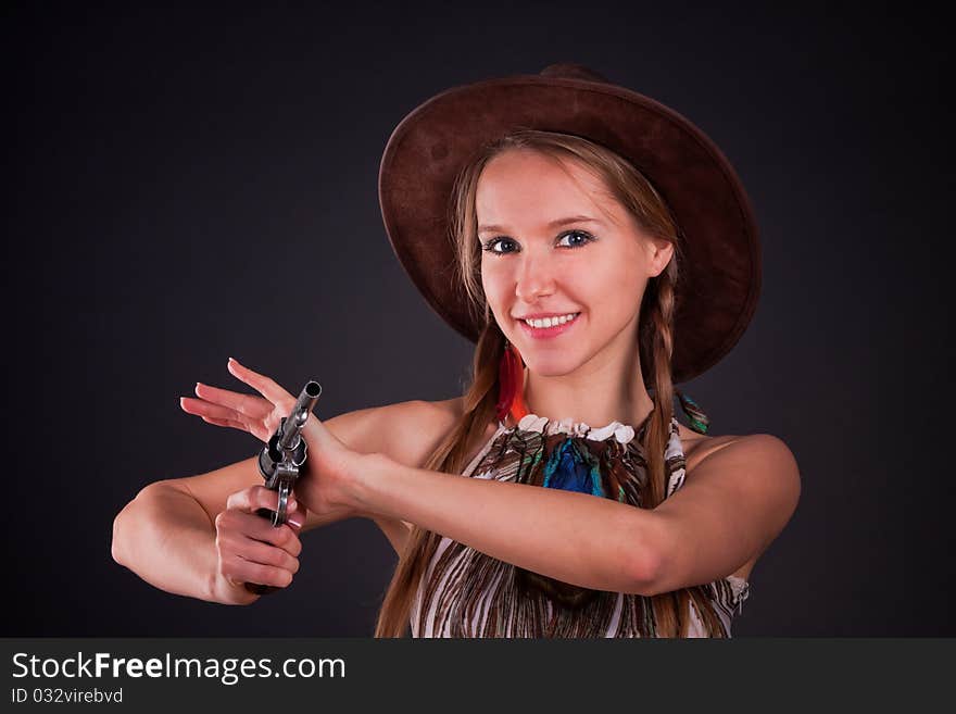 The American Indian girl in a cowboy's hat holds a pistol