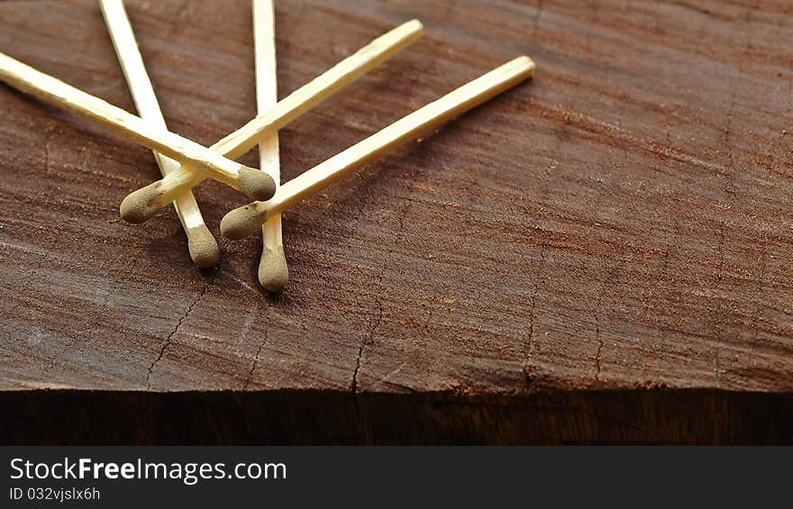 Five matches on a block of aged and textured wood. Five matches on a block of aged and textured wood.