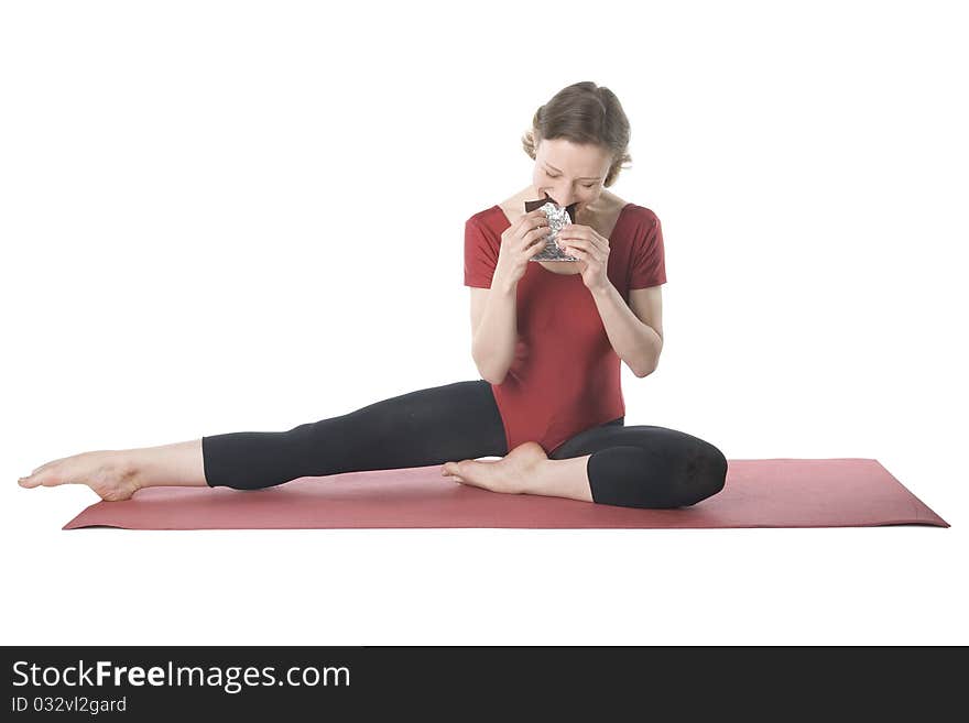 Young woman in sports clothes eating chocolate. Young woman in sports clothes eating chocolate