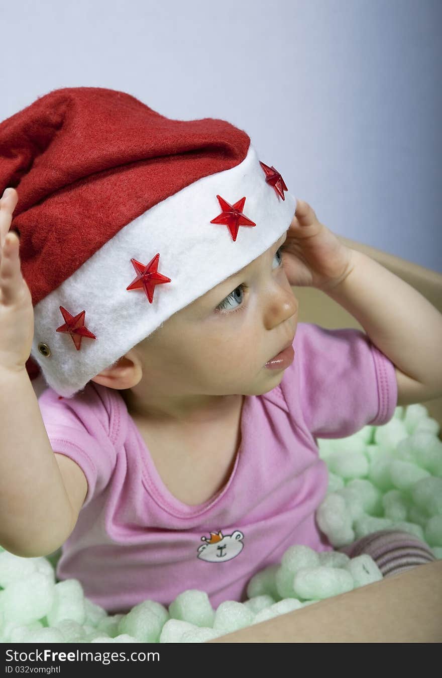 Santa Claus baby with santa hat sitting in a box. Santa Claus baby with santa hat sitting in a box