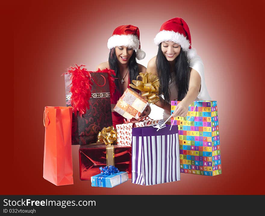 Two beautiful ladys are opening gifts. Two beautiful ladys are opening gifts