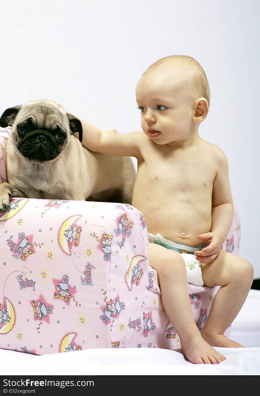 Young baby girl caressing a pug puppy. Young baby girl caressing a pug puppy