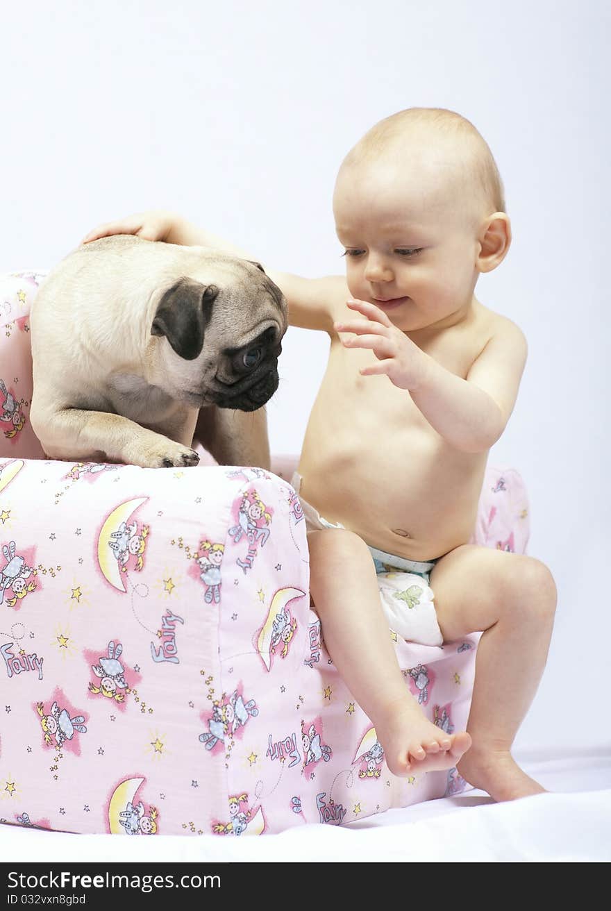 Young baby girl caressing a pug puppy. Young baby girl caressing a pug puppy