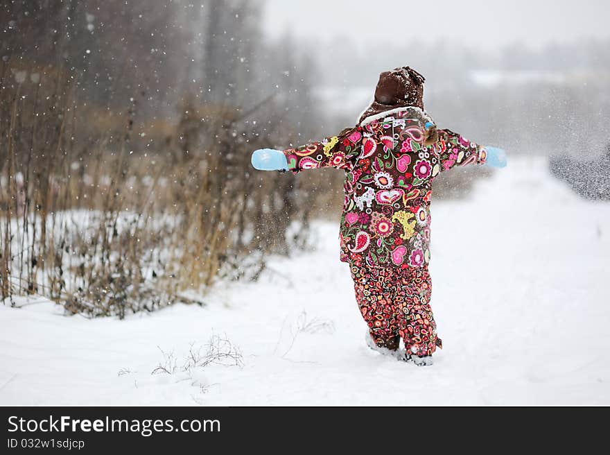 Small girl in strong snow fall