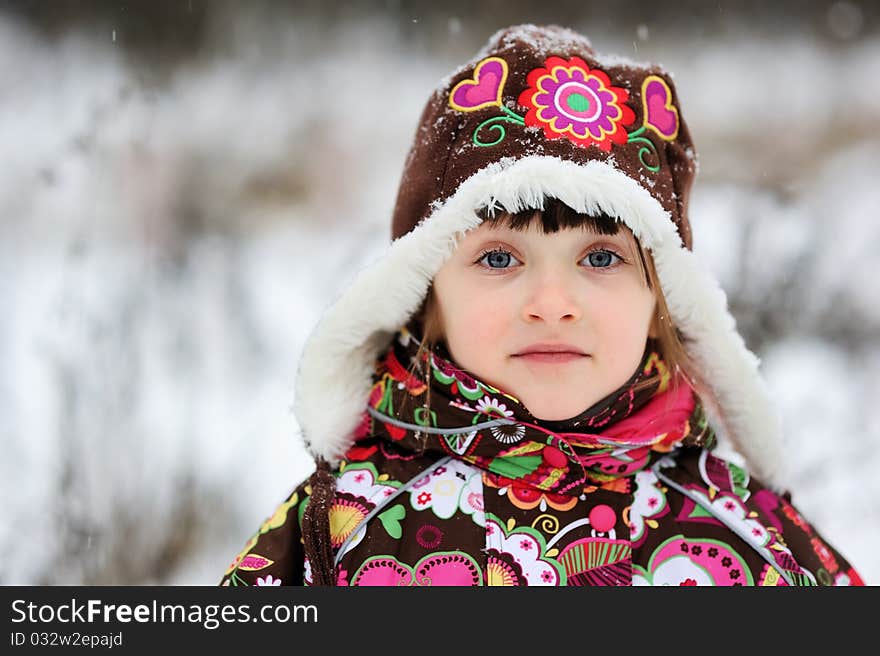 Adorable small girl in colorful winter clothes plays with snow in strong snowfall. Adorable small girl in colorful winter clothes plays with snow in strong snowfall