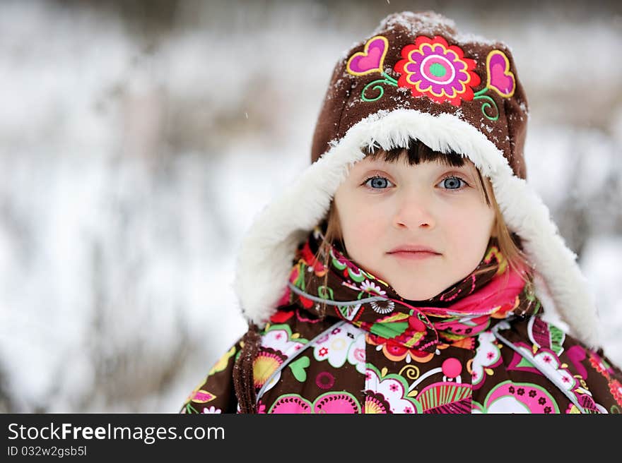 Adorable small girl in colorful winter clothes plays with snow in strong snowfall. Adorable small girl in colorful winter clothes plays with snow in strong snowfall