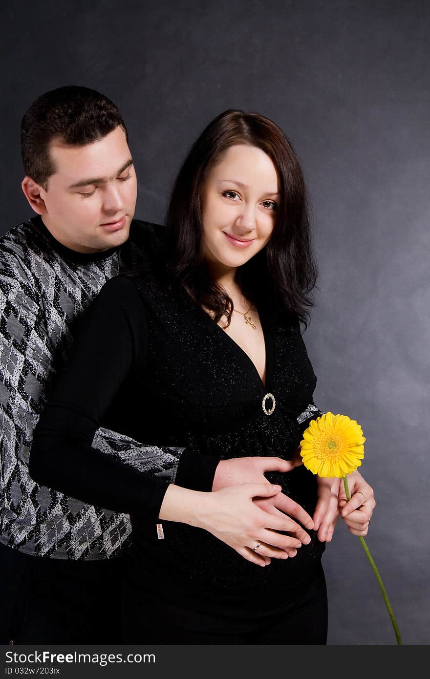 Pregnant couple posing, isolated on dark background. Pregnant couple posing, isolated on dark background