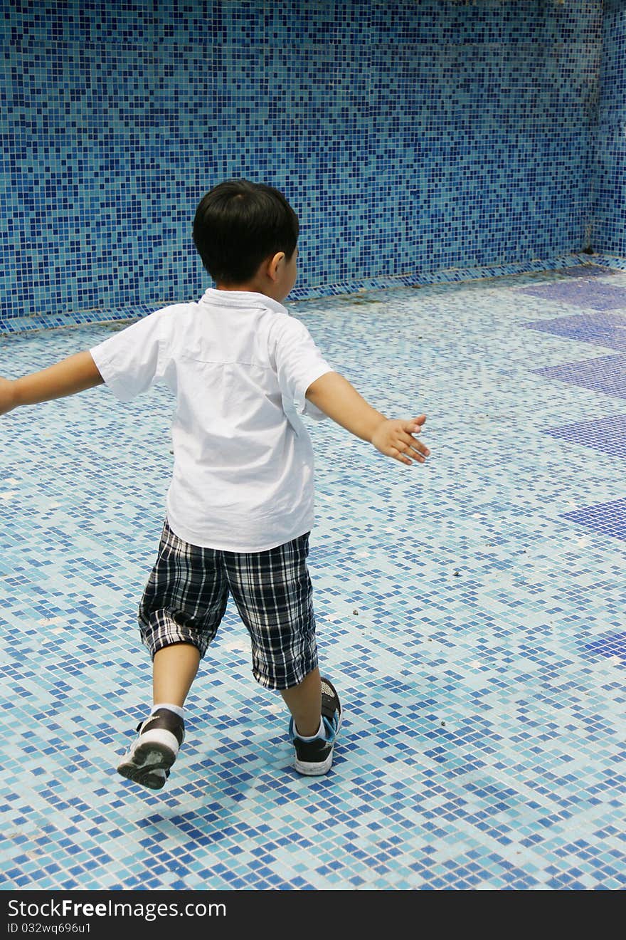 Picture of a little chinese boy spinning for fun