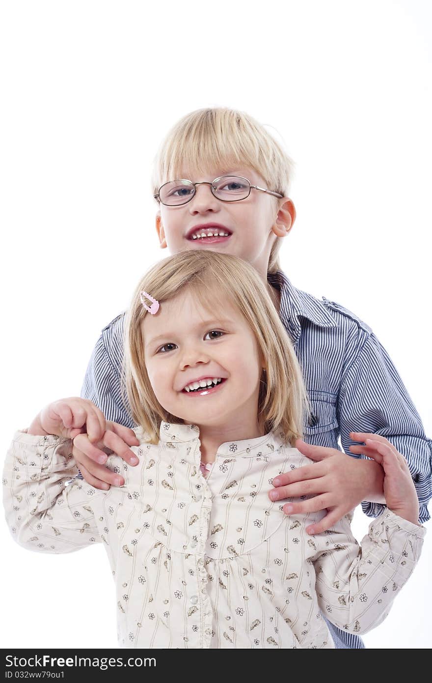 Children - portrait of brother and sister standing, holding each other - isolated on white