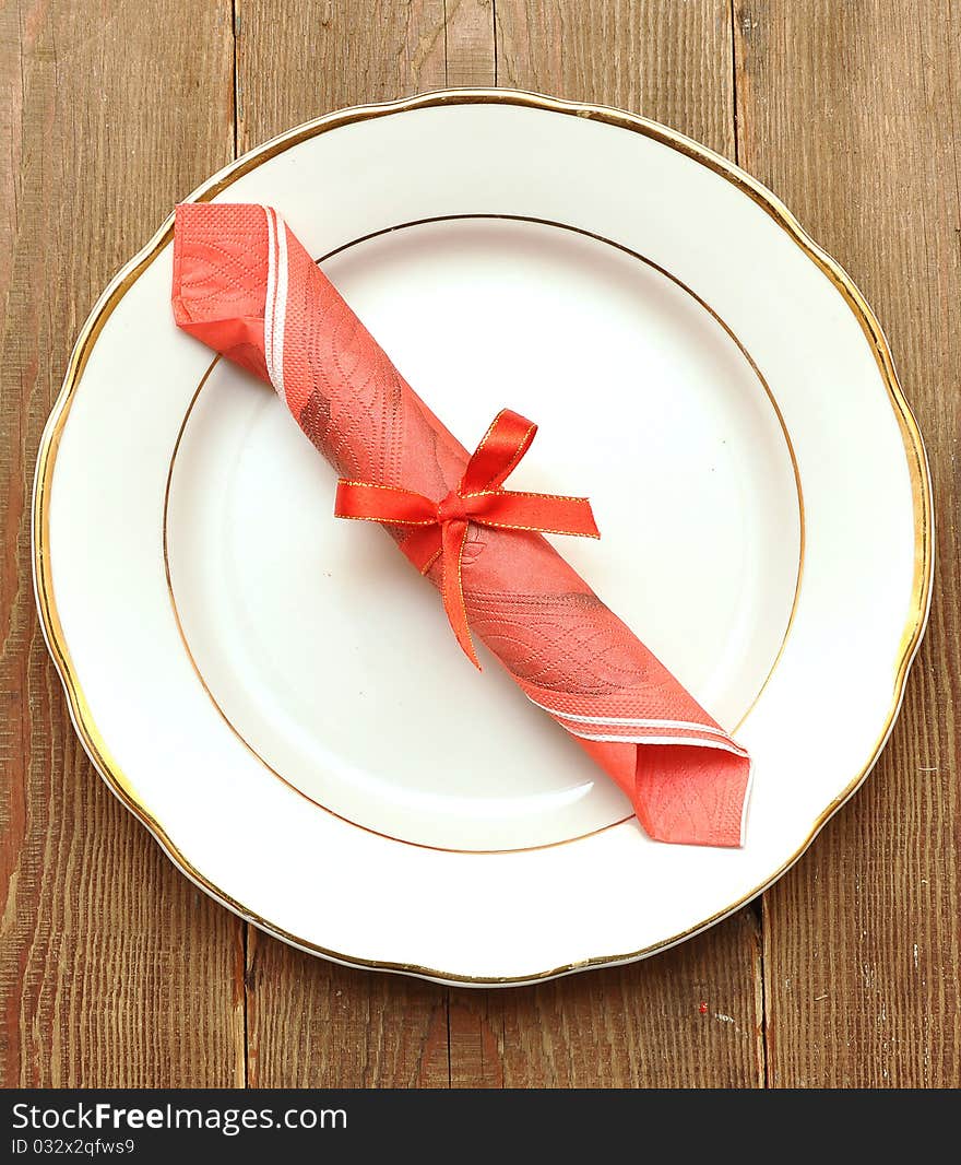 White plate and napkin on old wood background