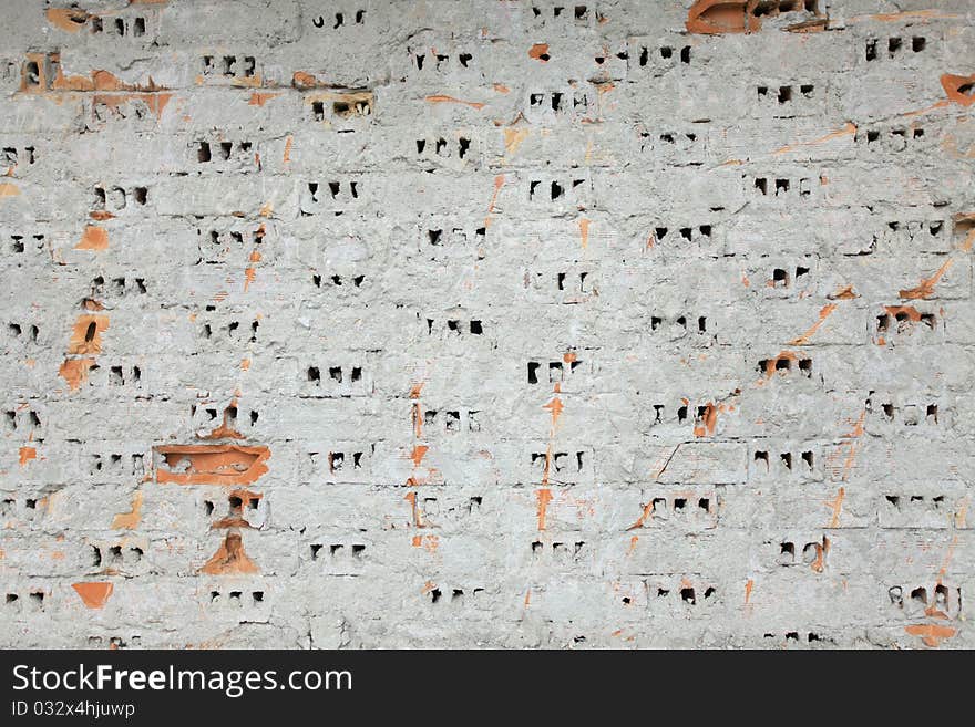 Unfinished stripped brick wall with some broken bricks