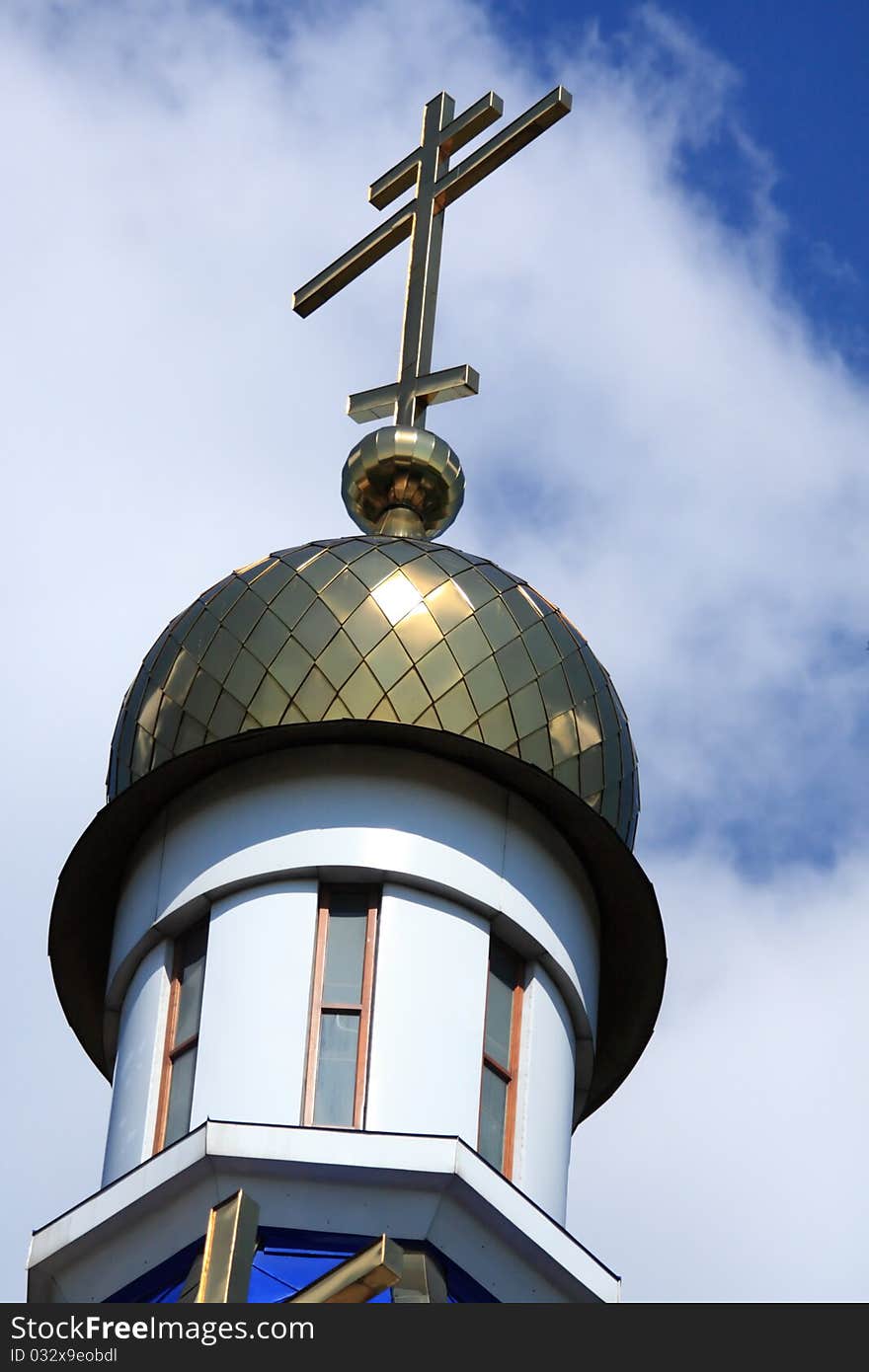 Dome with a cross of the Orthodox Church against the blue sky and clouds. Dome with a cross of the Orthodox Church against the blue sky and clouds