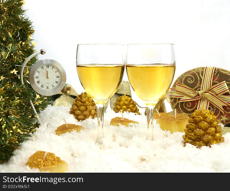 Clock showing twelve, two glasses with wine