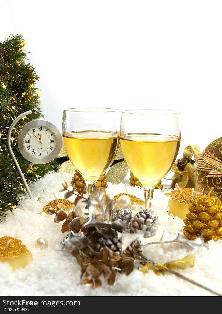 Clock showing twelve, two glasses with wine