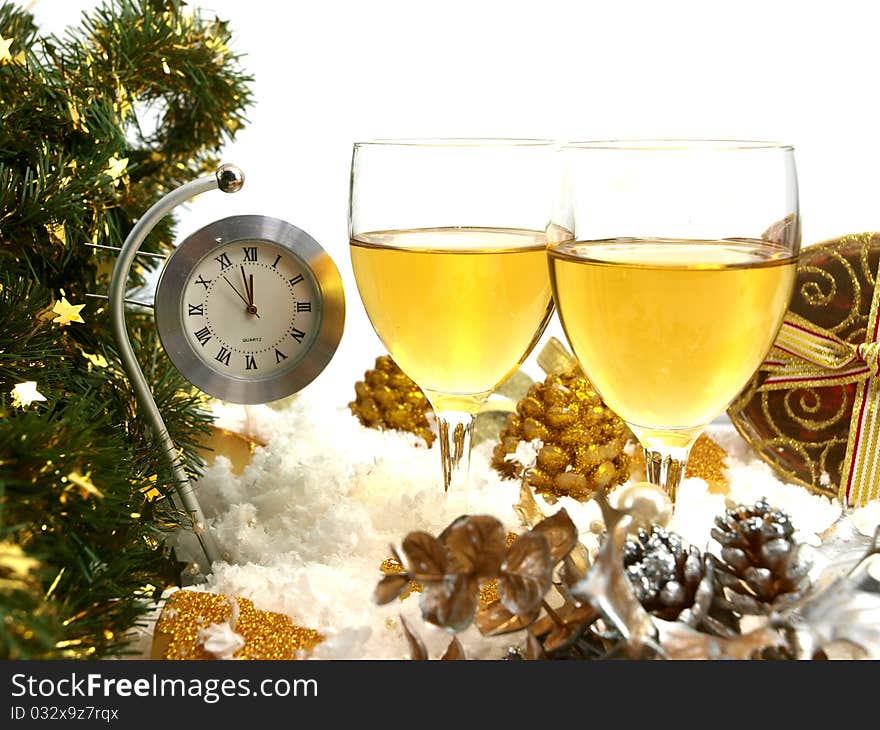 Clock showing twelve, two glasses with wine