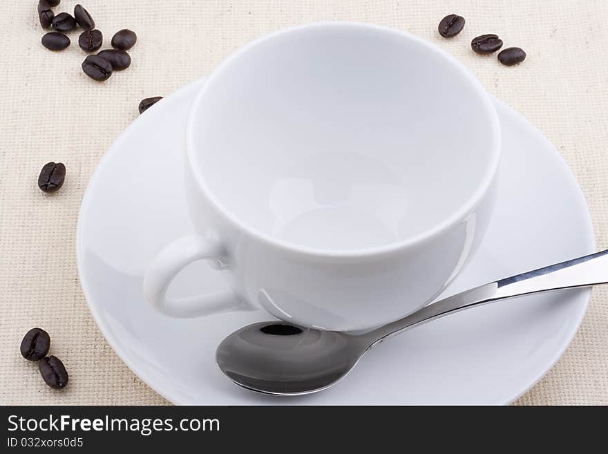 Empty ceramic cup with a saucer on a white background.