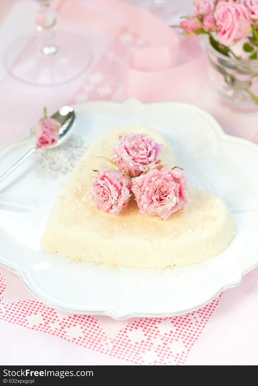 Heart-shaped ricotta dessert with candied roses. Heart-shaped ricotta dessert with candied roses