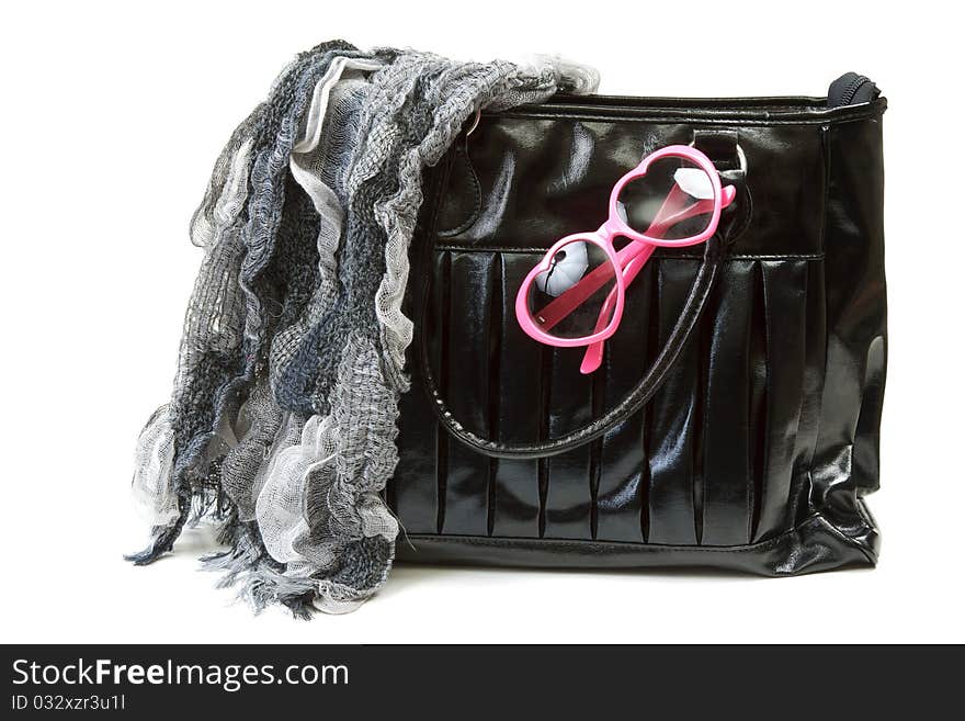 Feminine bag with scarf and rose-colored glasses on white background