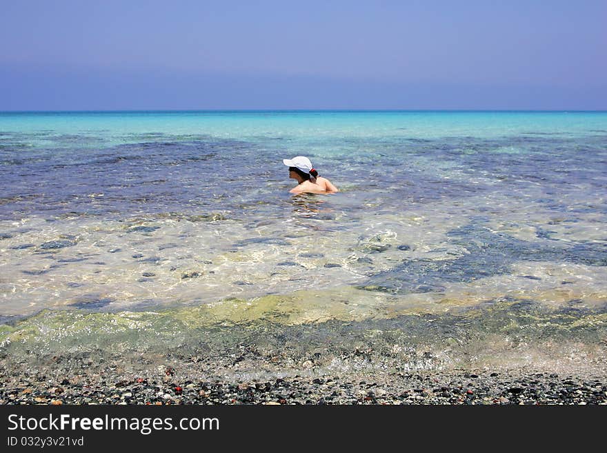 Young woman swimming at tropical island beach